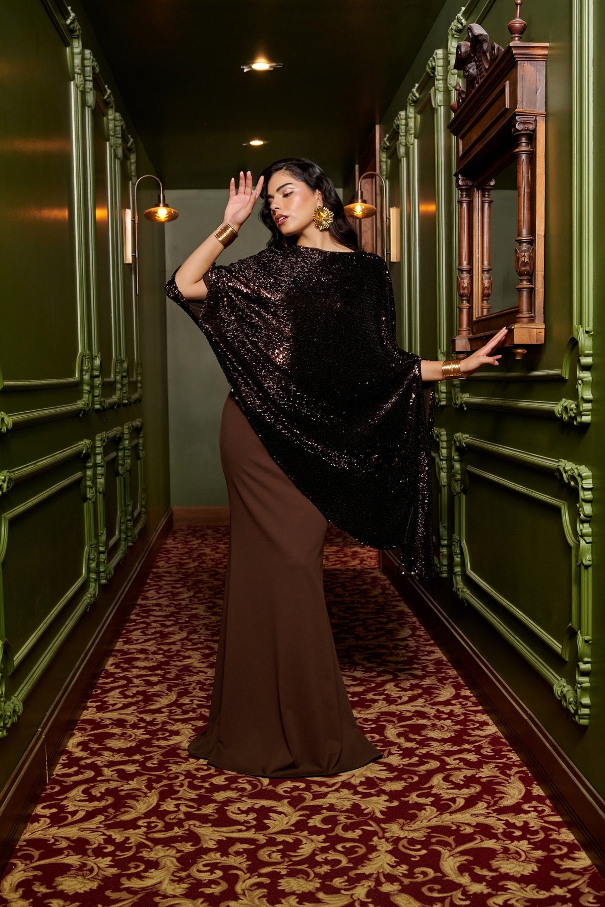 Mocha Glow chocolate brown evening gown with an asymmetric black sequin cape overlay and a floor-length fitted skirt.