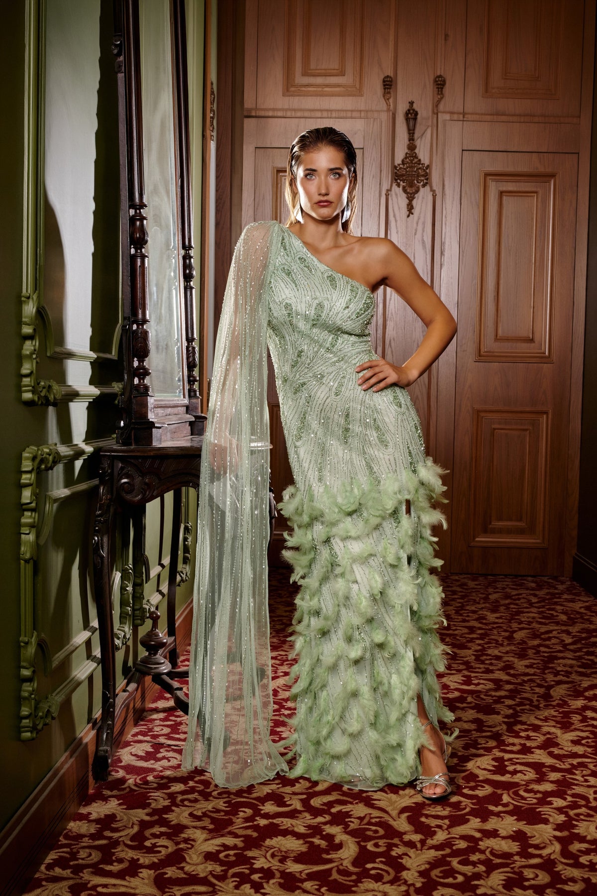 Mint Muse mint green one-shoulder embellished evening gown with feather detailing and a sheer cape sleeve.