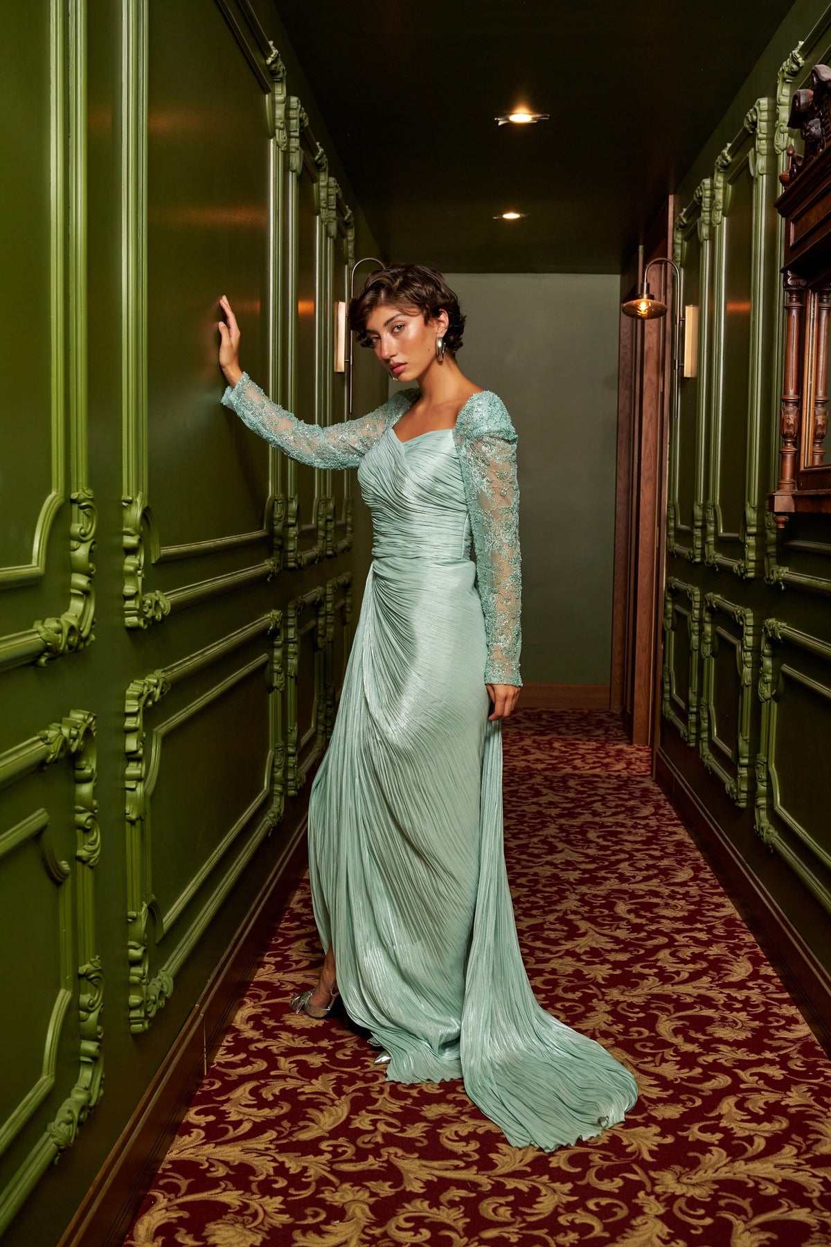 Mint Grace mint green draped evening dress with an asymmetric neckline, lace sleeve and floor-length silhouette.