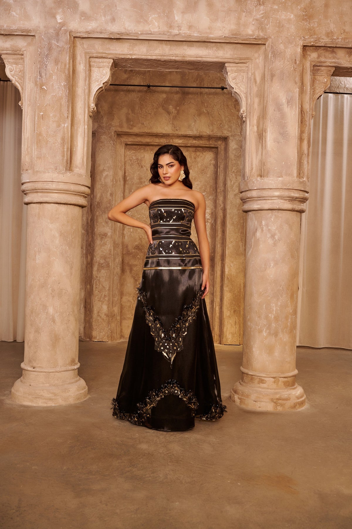 Golden Frame black evening gown with a strapless bodice, gold bands and an ornate embellished floor-length overlay.