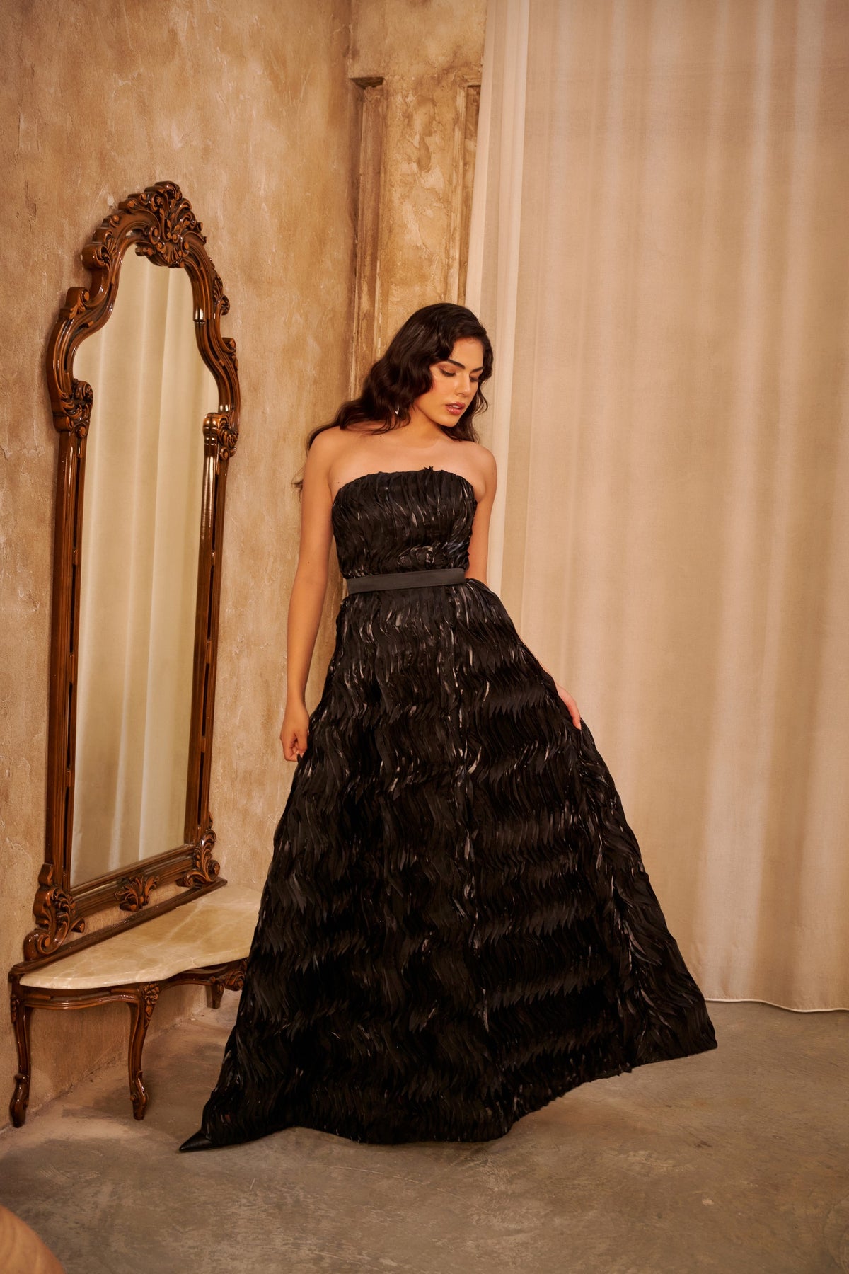 Midnight Waves black evening gown with a strapless ruched bodice, defined waist and voluminous layered textured skirt.