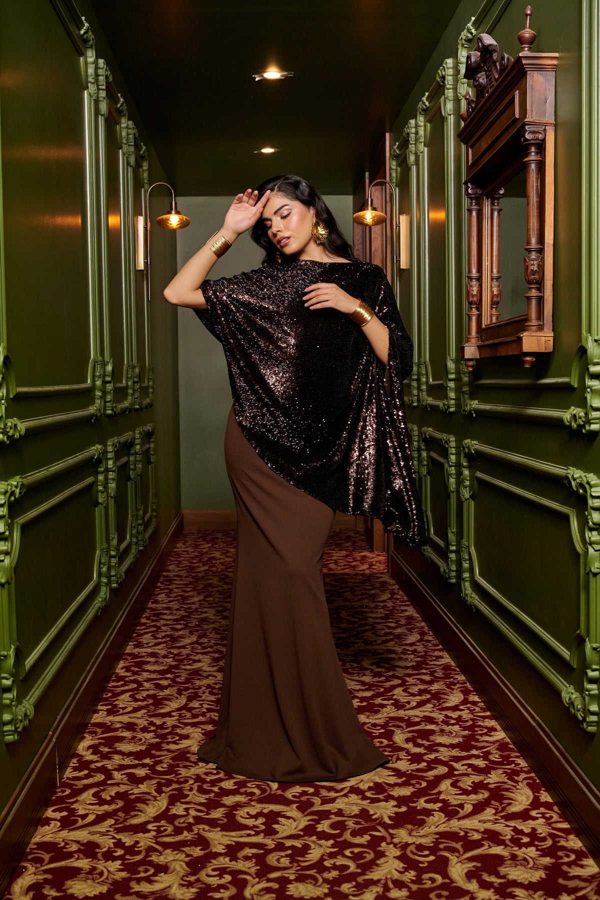 Mocha Glow chocolate brown evening gown with an asymmetric black sequin cape overlay and a floor-length fitted skirt.