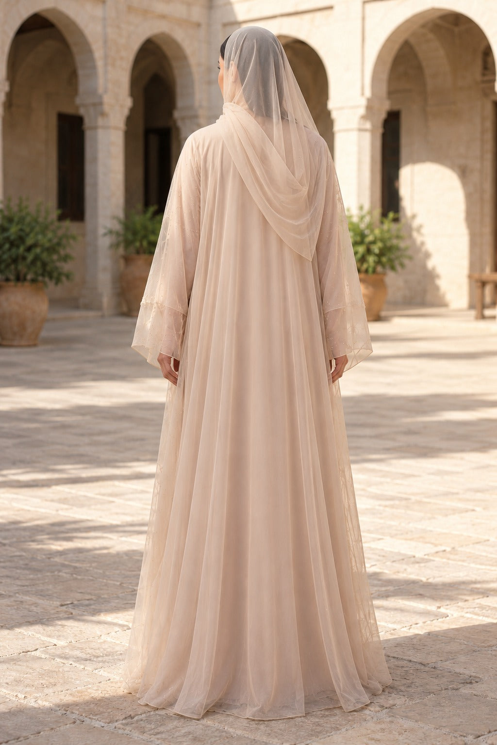 Aurelle champagne beige embellished abaya with floral front detailing, a rounded neckline and long, wide sleeves, back view