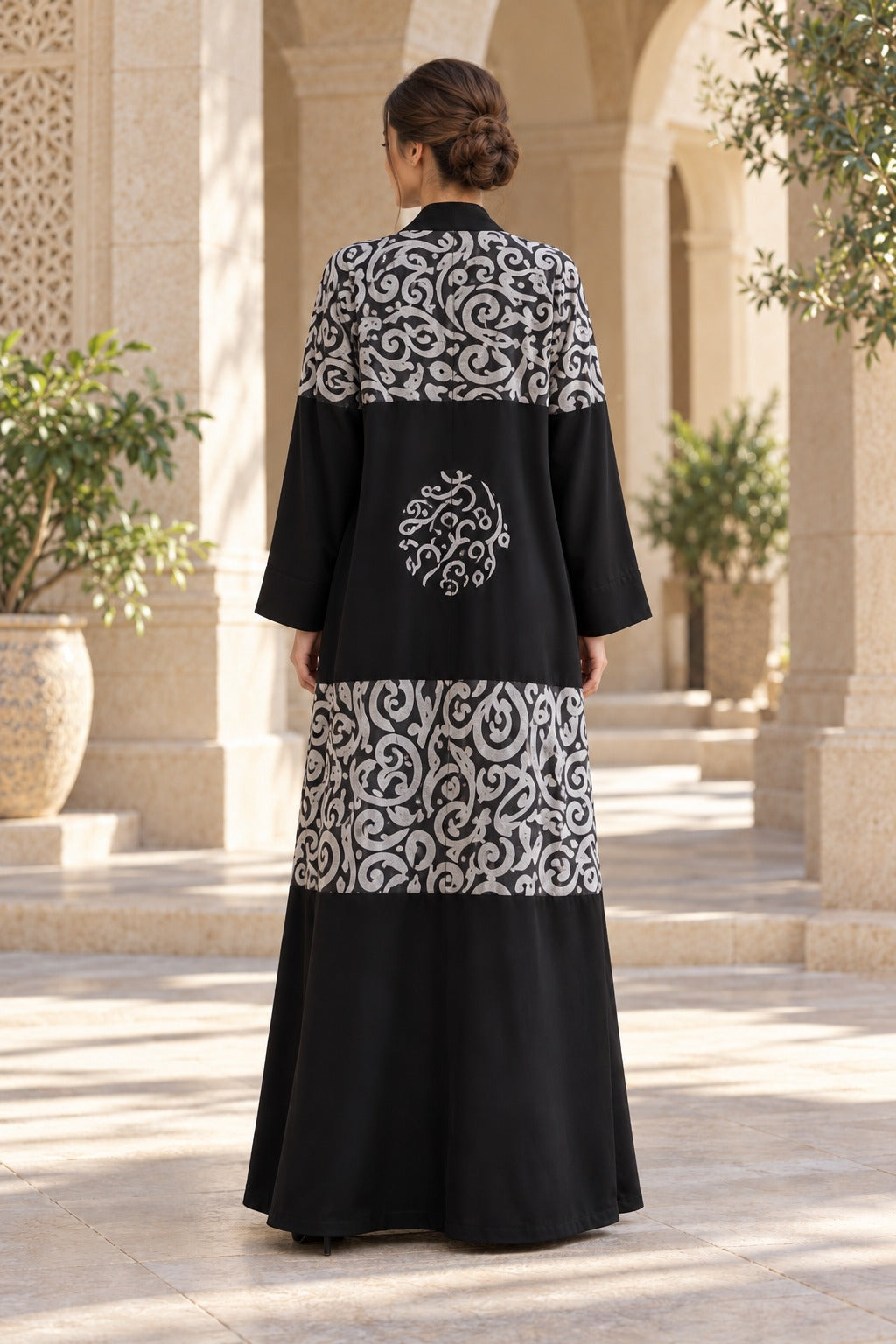 Rasm black and ivory abaya with bold patterned bands, a central back motif and a loose, full-length silhouette, back view