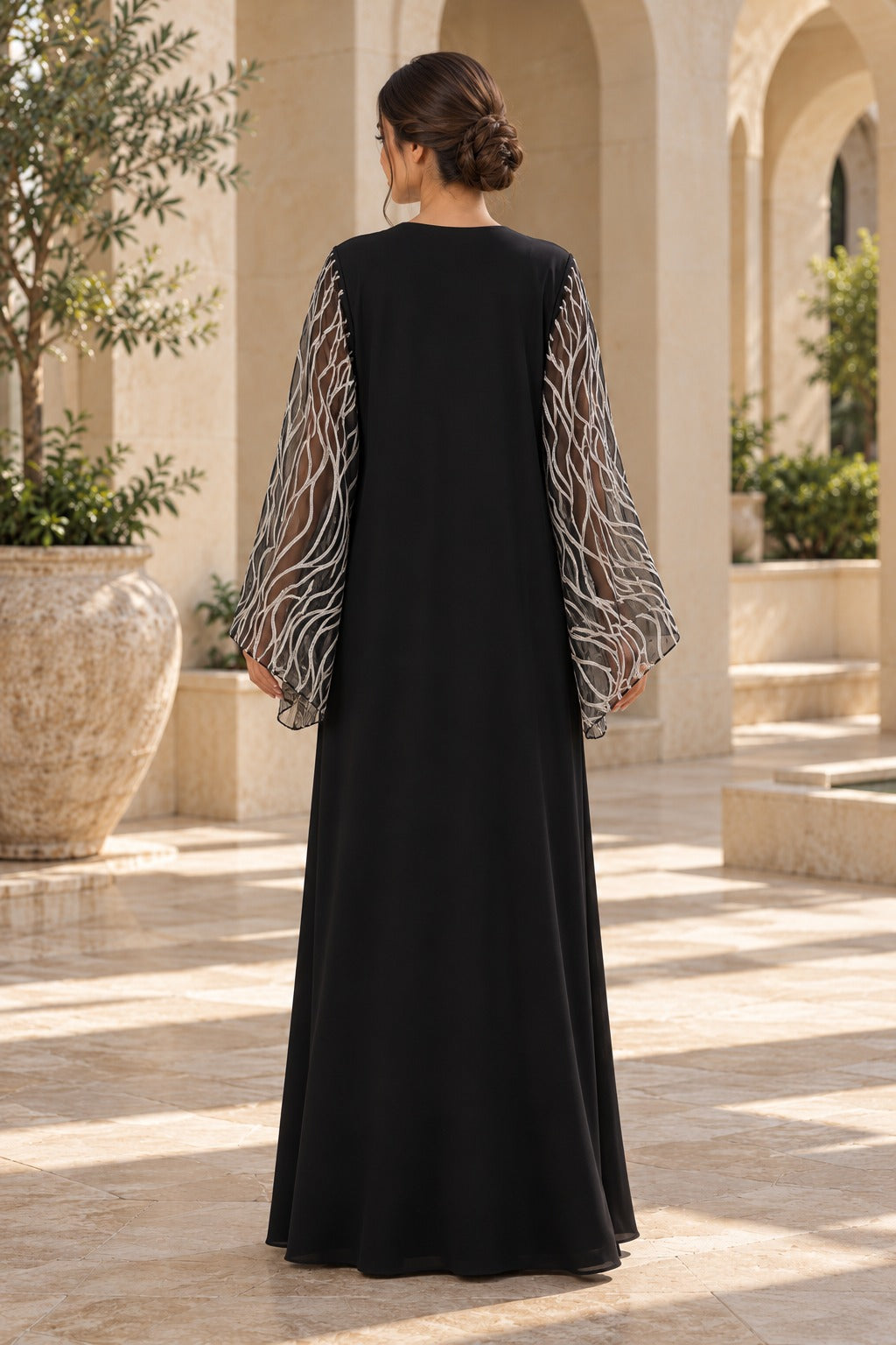 Serein black evening abaya with silver-toned neckline embellishment and sheer flared sleeves featuring leaf-like patterns, back view