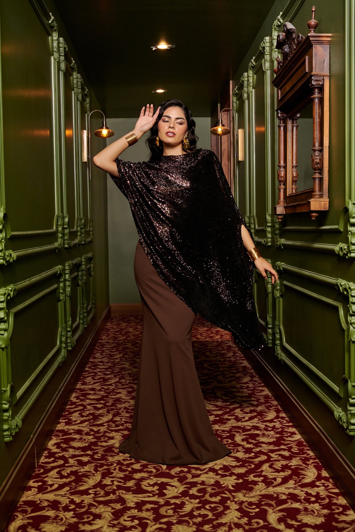 Mocha Glow chocolate brown evening gown with an asymmetric black sequin cape overlay and a floor-length fitted skirt.