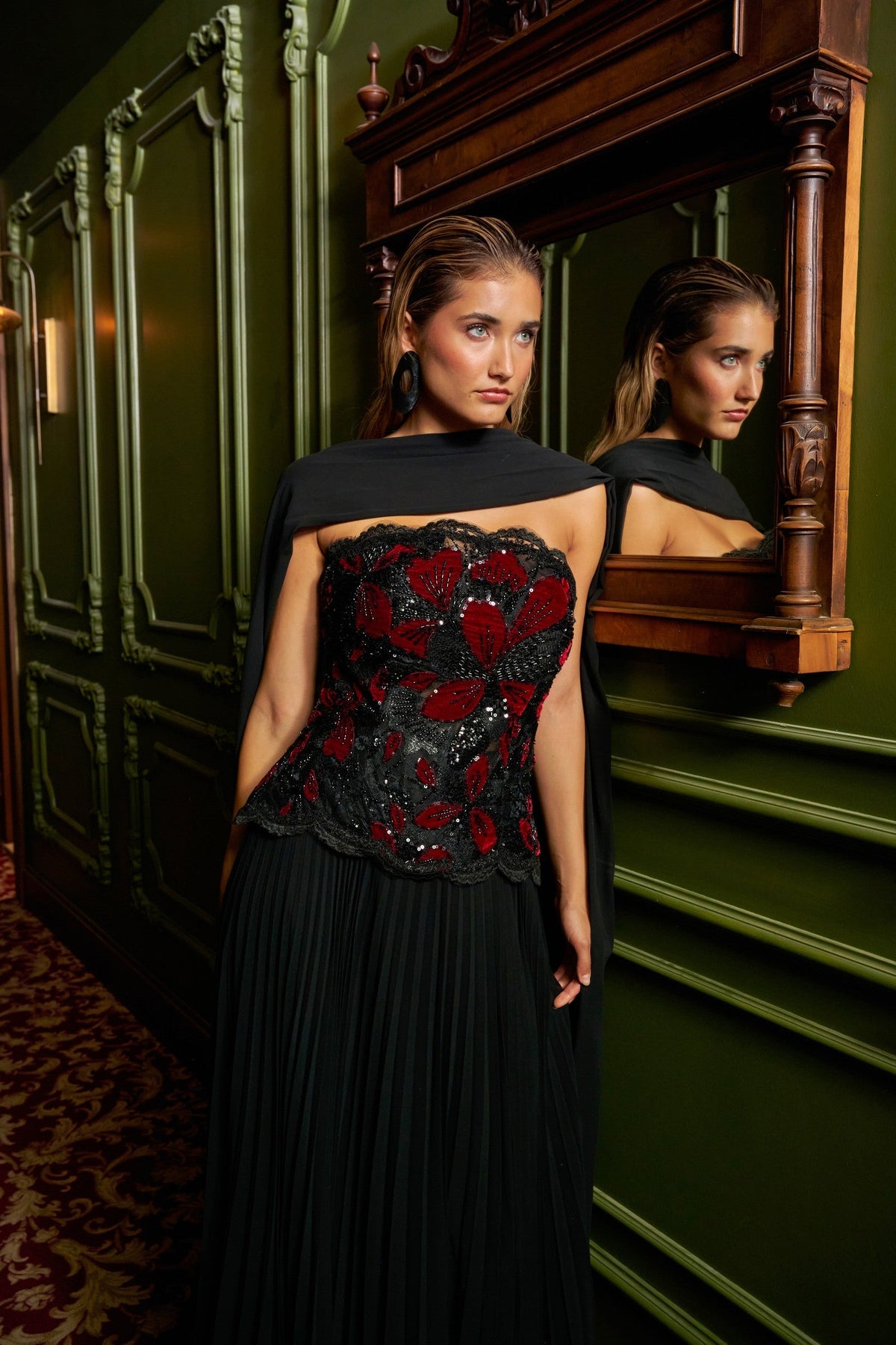 Floral Cascade evening gown in Black and Red with a strapless black and red floral-appliqué bodice, flowing pleated skirt and sheer draped scarf.