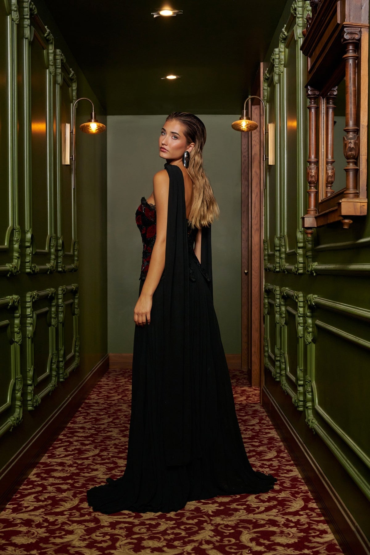 Floral Cascade evening gown in Black and Red with a strapless black and red floral-appliqué bodice, flowing pleated skirt and sheer draped scarf.