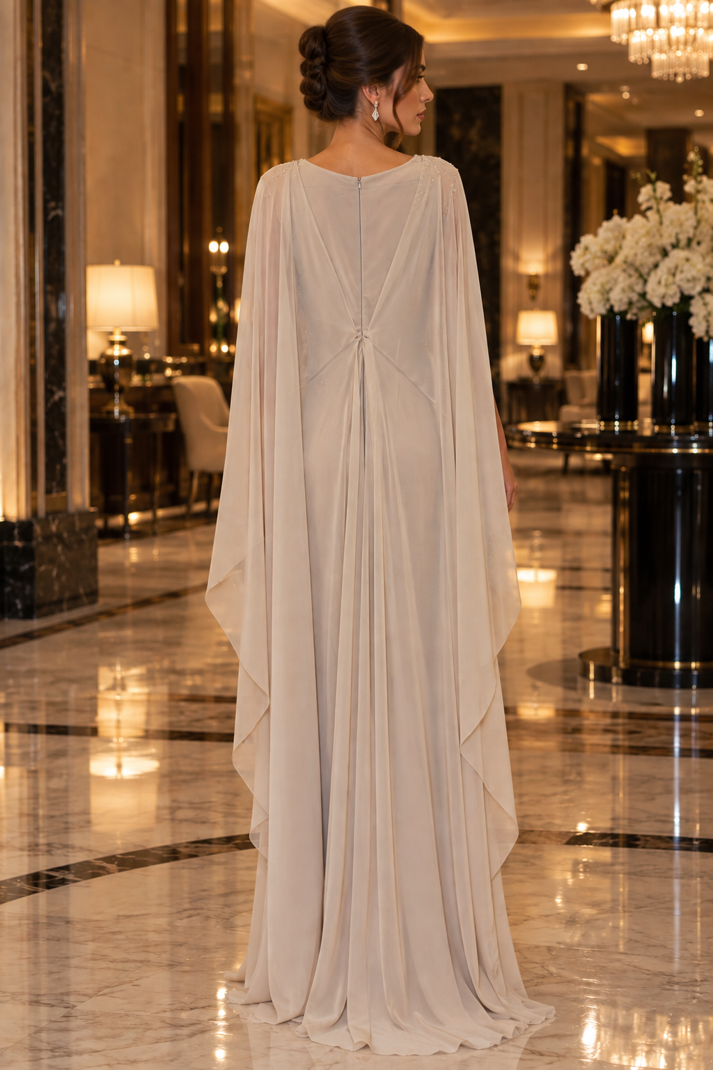 Éclat Gown in Champagne and Ivory, a beaded lace evening gown with a sheer draped cape and a gathered waist.