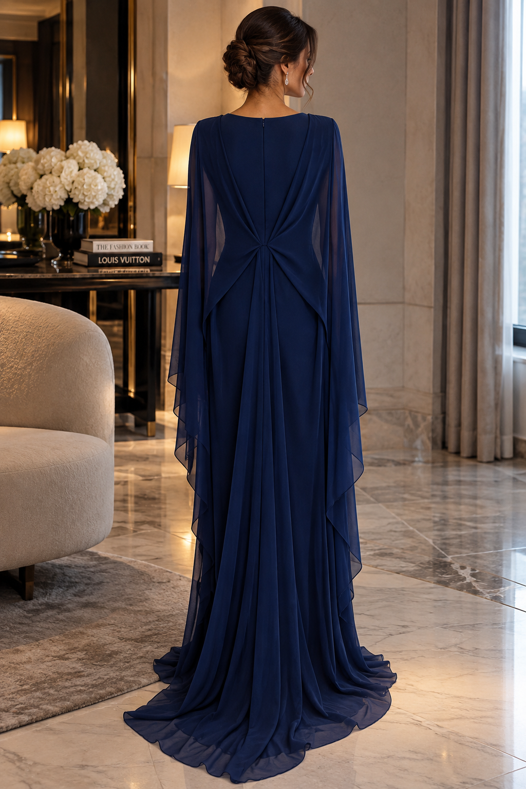 Éclat Gown in Navy Blue, a draped evening gown with sheer cape sleeves and a gathered waist.