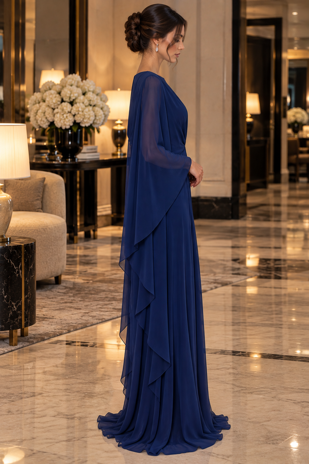 Éclat Gown in Navy Blue, a draped evening gown with sheer cape sleeves and a gathered waist.