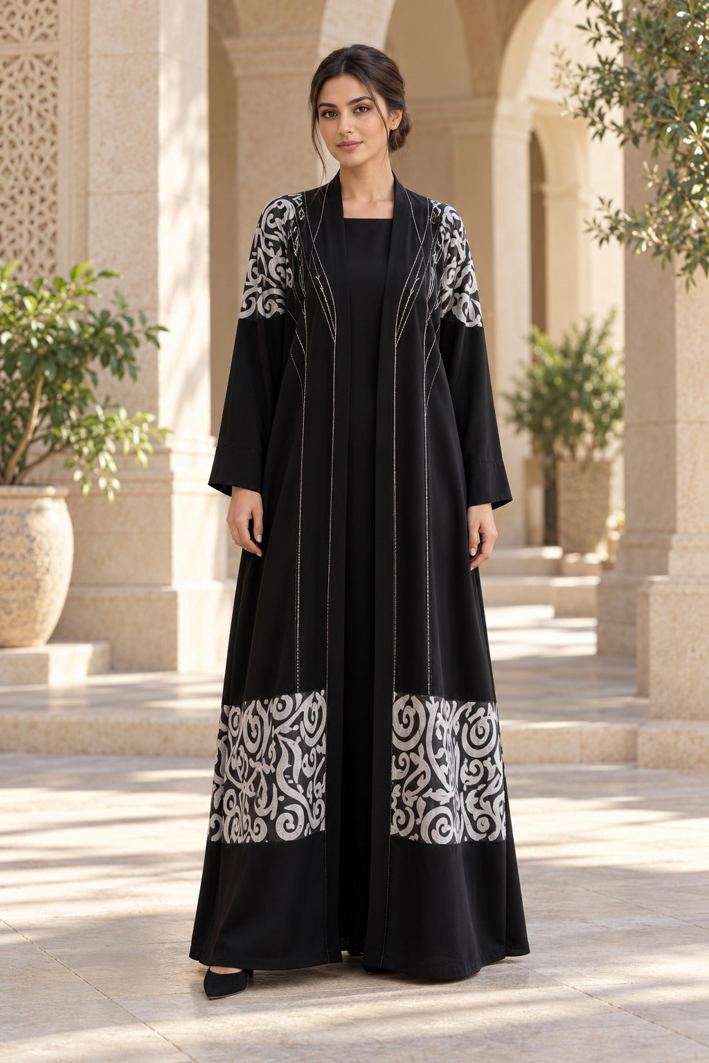 Rasm black and ivory abaya with bold patterned bands, a central back motif and a loose, full-length silhouette, front view