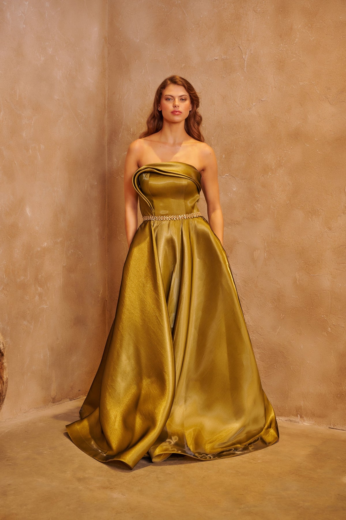 Gilded Olive satin gown with a sculpted strapless bodice, crystal waist detail and a full skirt.