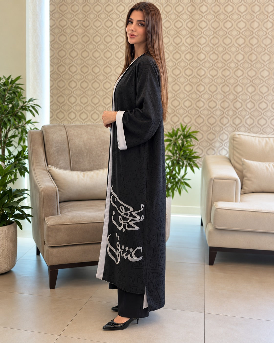 Harf black open-front abaya with silver-grey calligraphy, tonal patterning and long sleeves with contrasting turn-back cuffs, side view