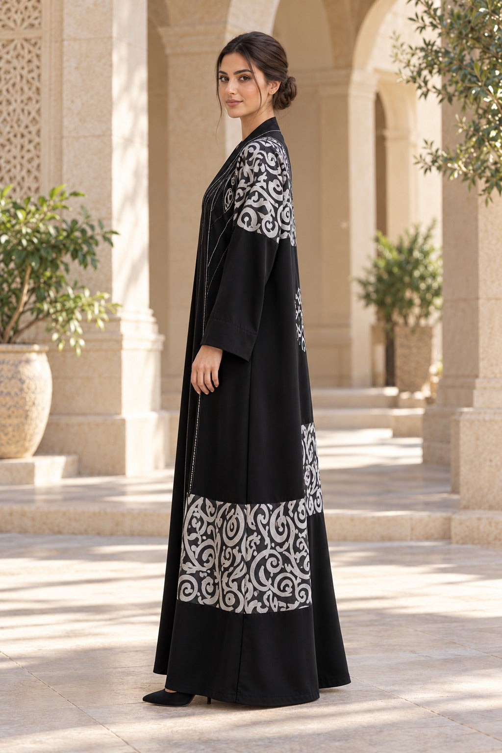 Rasm black and ivory abaya with bold patterned bands, a central back motif and a loose, full-length silhouette, side view