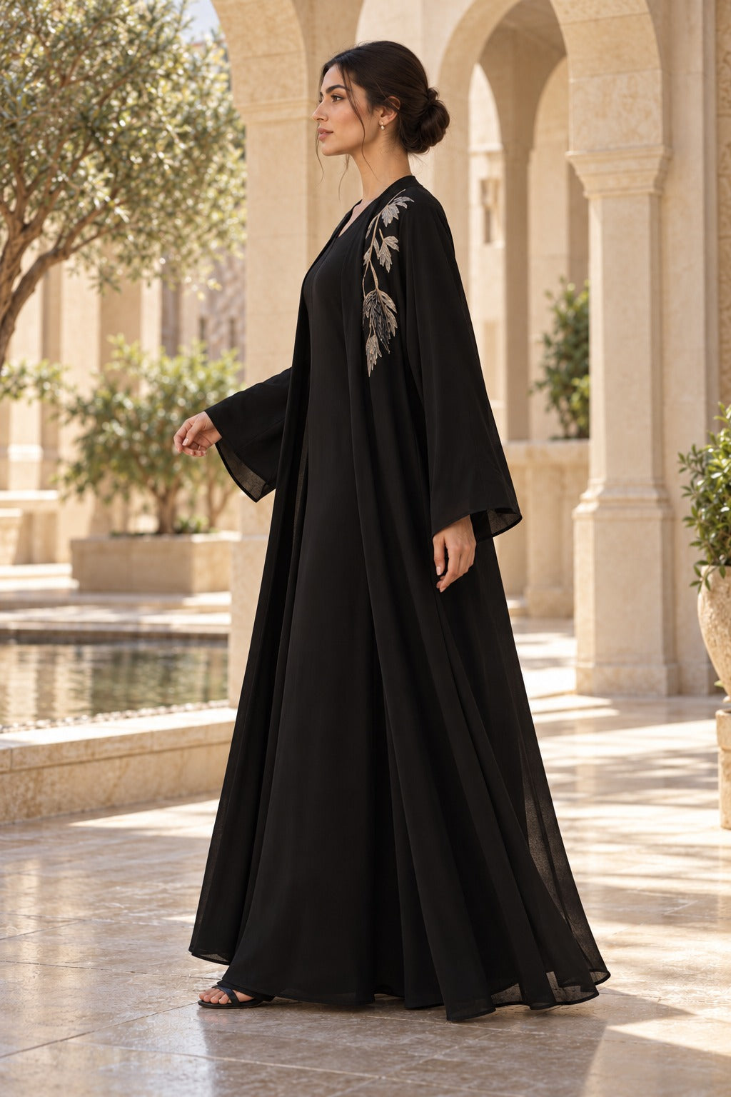 Willow black abaya with oversized botanical back detailing, champagne-toned accents and long, wide sleeves, side view
