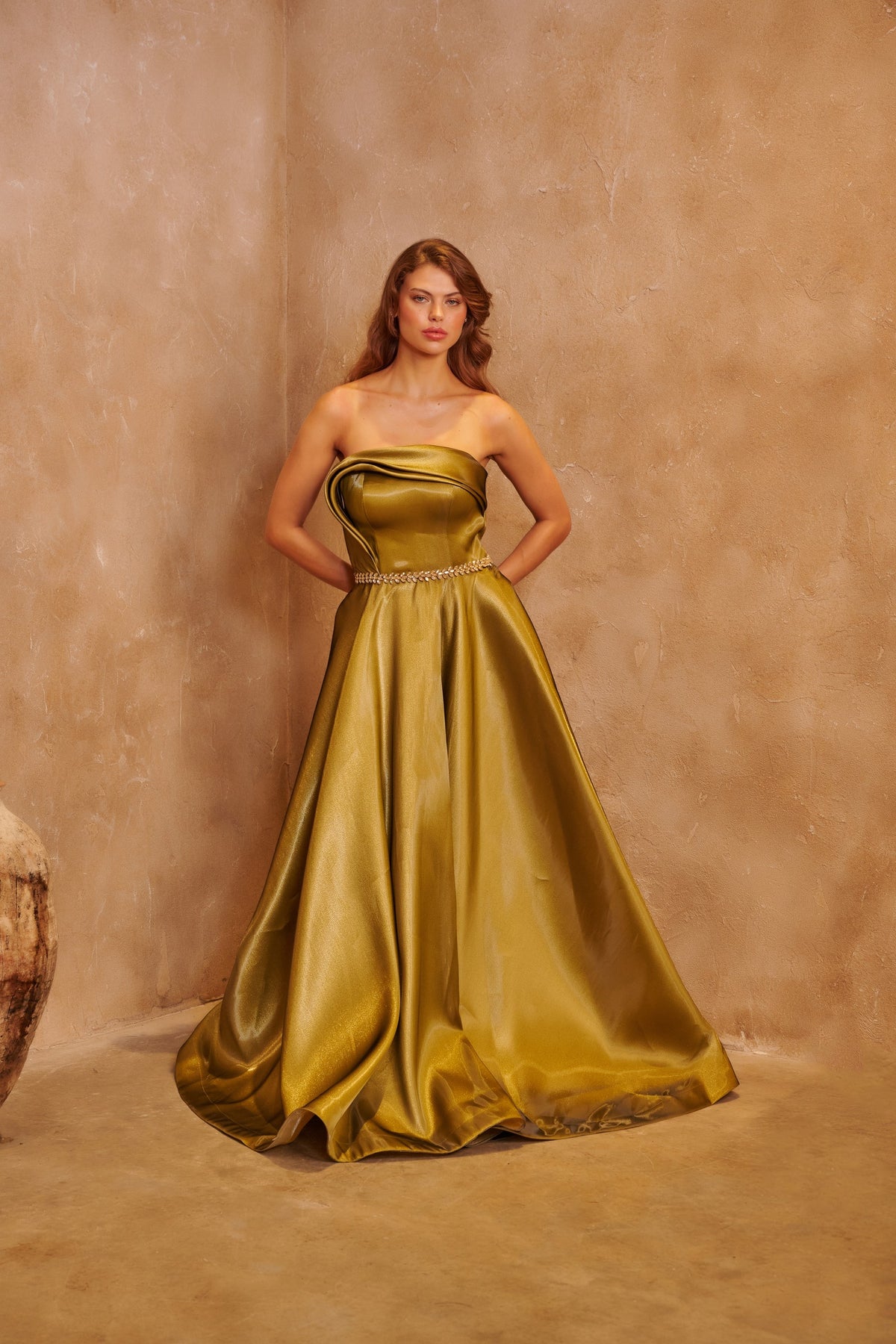 Gilded Olive satin gown with a sculpted strapless bodice, crystal waist detail and a full skirt.