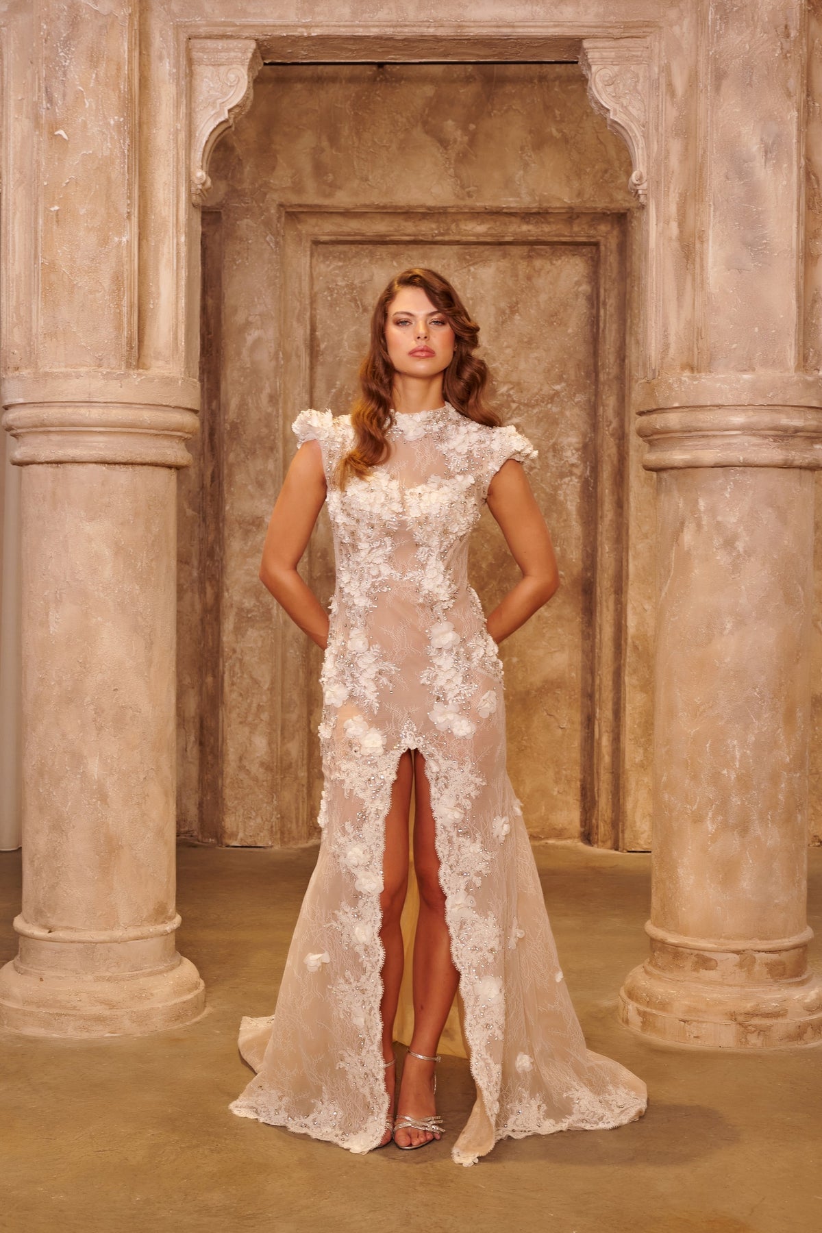 Ivory Lace white evening dress with a high neckline, sheer fitted bodice, floral appliqués and a front slit.