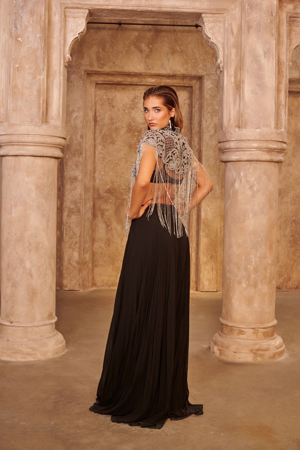 Silver Rain black evening gown with an ornate silver cape, cascading beaded fringe and a fluid floor-length silhouette.
