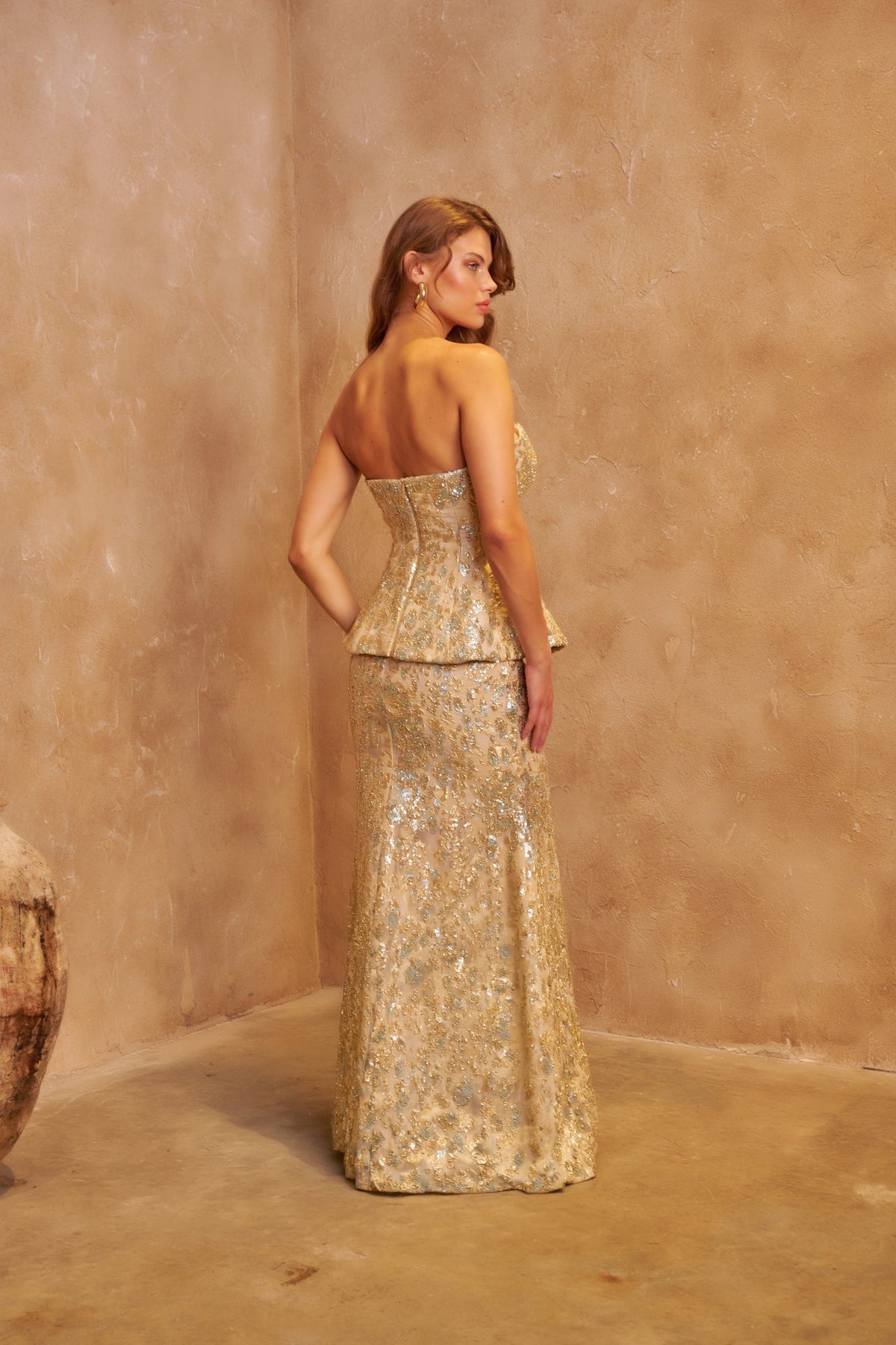 Aurelia gold embellished gown with a strapless peplum bodice and fitted floor-length skirt.