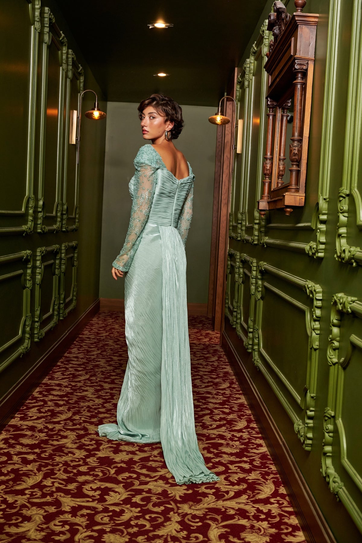 Mint Grace mint green draped evening dress with an asymmetric neckline, lace sleeve and floor-length silhouette.