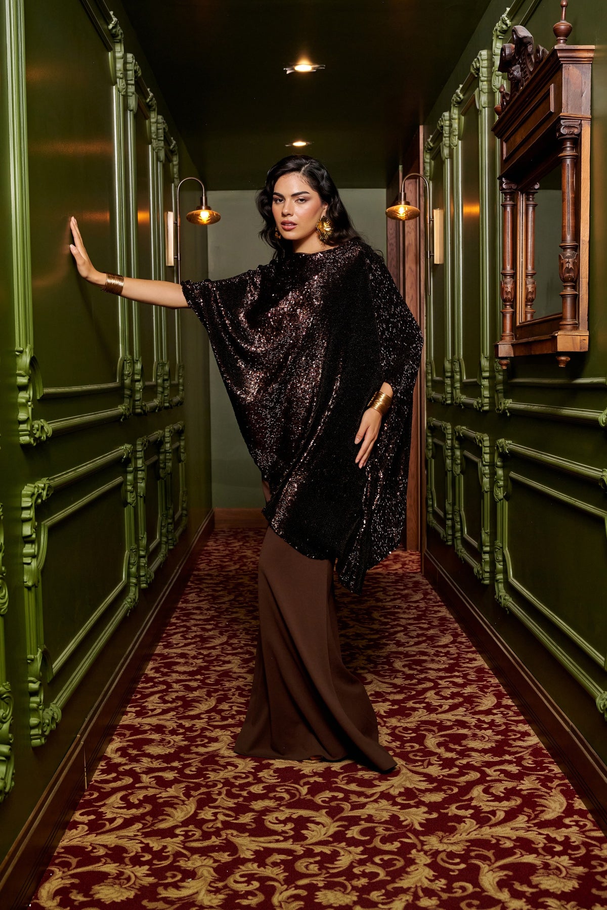 Mocha Glow chocolate brown evening gown with an asymmetric black sequin cape overlay and a floor-length fitted skirt.