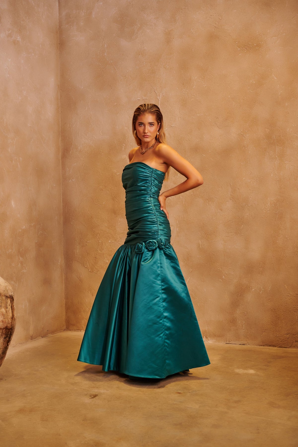 Emerald Rose green evening dress with floral-inspired embellishment and a sculpted fitted silhouette.